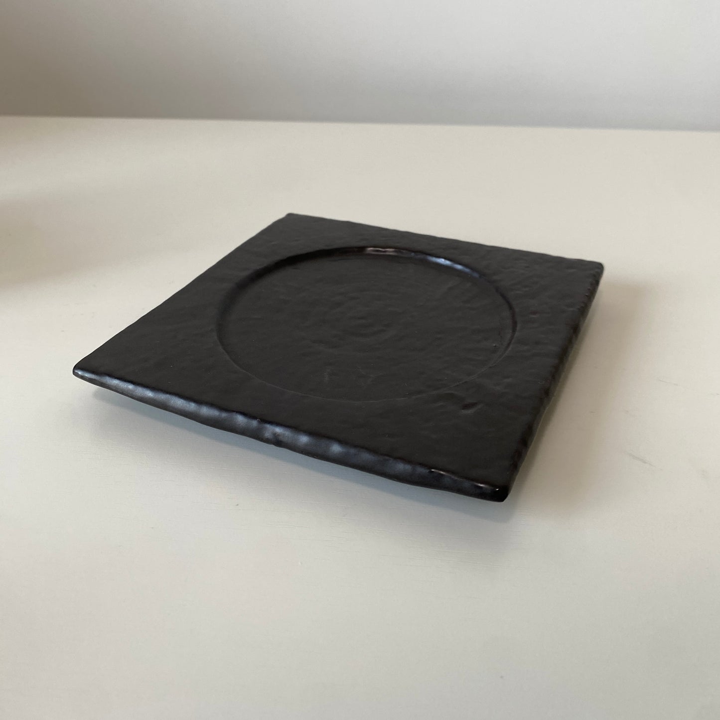 Black square plate on a white surface