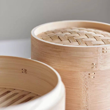 Close-up of a bamboo steamer with woven lid on a white surface.