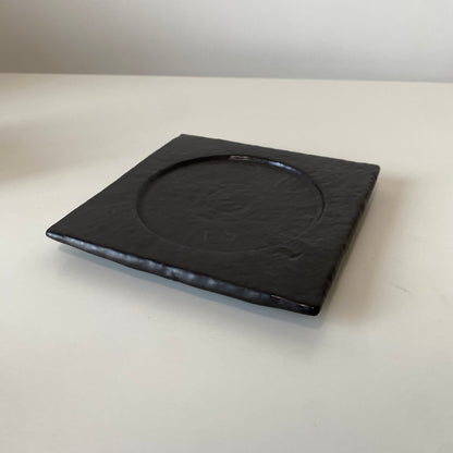 Black square plate on a white surface