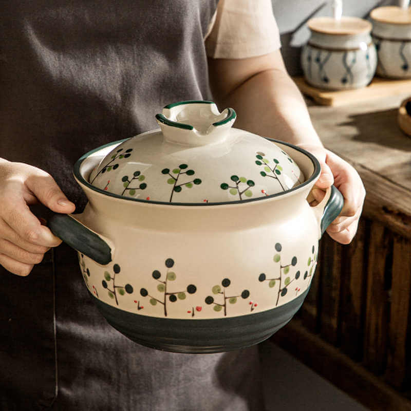 Japanese ceramic casserole with botanical berry pattern in use wabi-sabi style hot pot cooking
